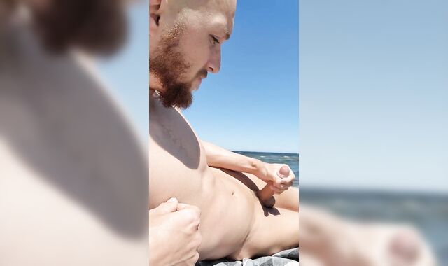 Brainwashed gooner dude masturbates his bone on public beach