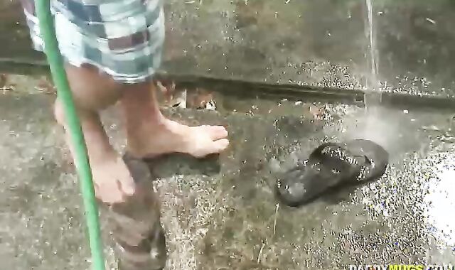 Father Drains Off while Washing Truck