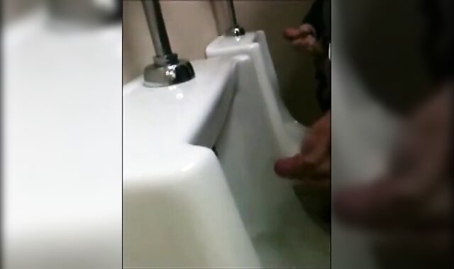 two slim dicks getting wanked at the urinals