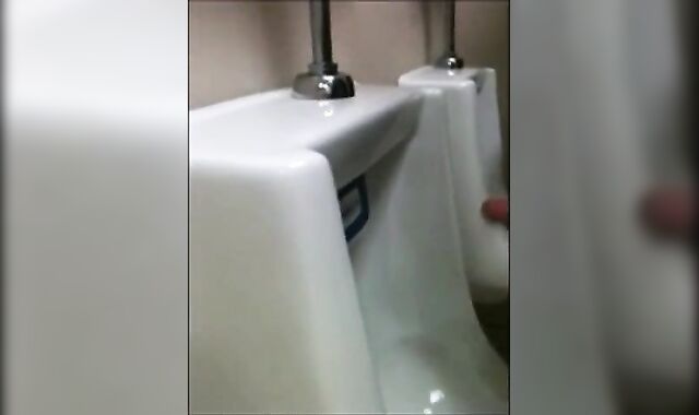 two slim dicks getting wanked at the urinals