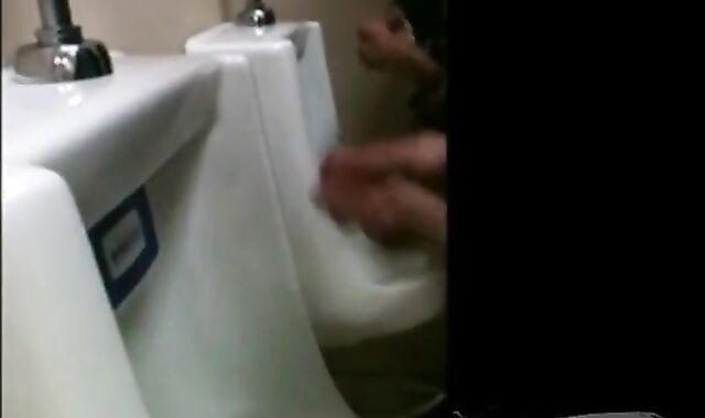 two slim dicks getting wanked at the urinals