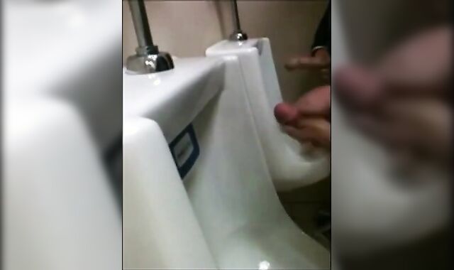 two slim dicks getting wanked at the urinals