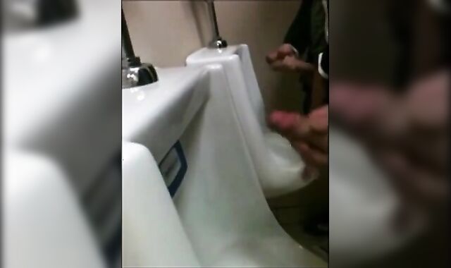 two slim dicks getting wanked at the urinals