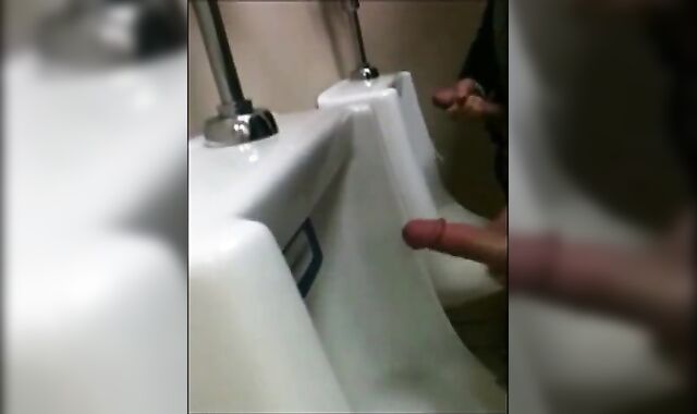 two slim dicks getting wanked at the urinals